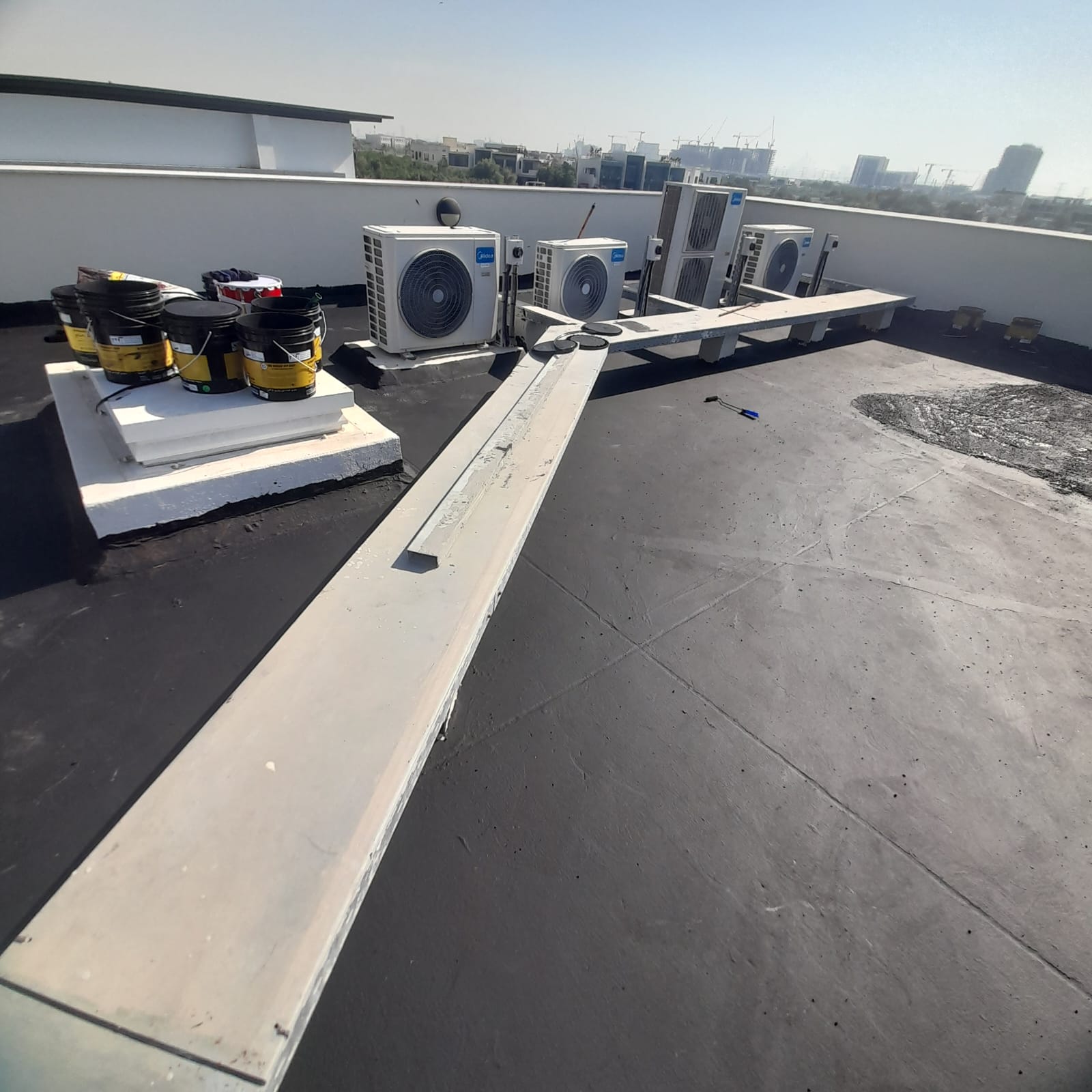 Applied bitumen membrane waterproofing on a roof by Fix It Mates, showcasing a seamless and durable layer designed to protect against water leaks and environmental elements.